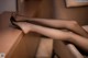 A woman's legs are sitting on a couch.