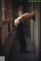 A woman with long black hair standing in a hallway.