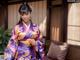 A woman in a purple kimono posing for a picture.