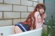 A woman with long red hair sitting in a bathtub.