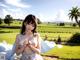 A woman in a white dress standing in a field.