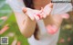 A woman holding a pink flower in her hands.