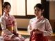 A couple of women sitting on top of a wooden floor.