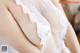 A close up of a woman wearing a white lingerie.