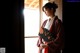 A woman in a red and white kimono holding a fan.